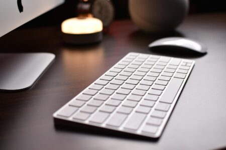 Professional workspace with mechanical keyboard on desk with monitor and creative tools
