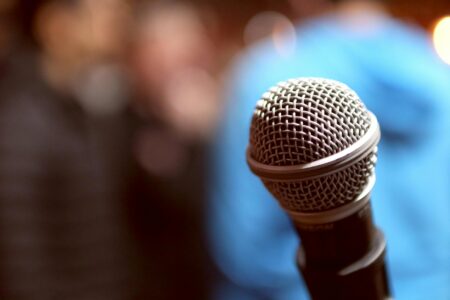 Professional microphone on stage with dramatic lighting for comedy performance