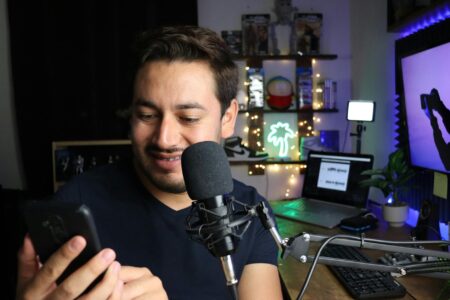 Person holding smartphone with voice recording interface displayed on screen