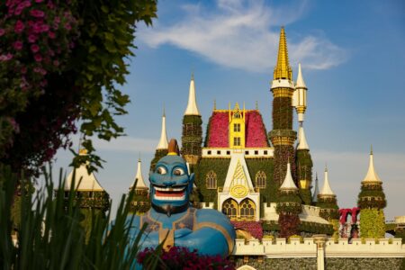 Fantasy castle structure in a theme park setting with visitors walking nearby