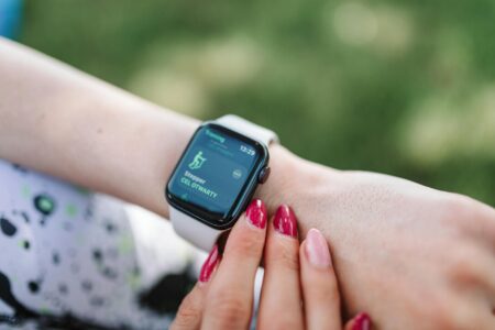 Person wearing a modern fitness tracker on their wrist displaying health metrics