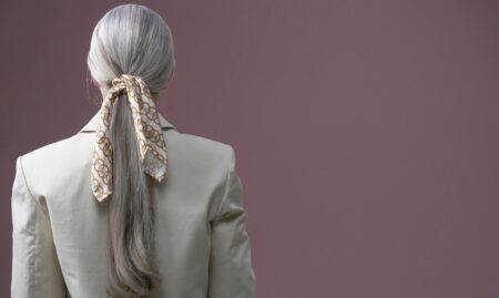 Elegant silk scarf draped over business attire showing professional styling