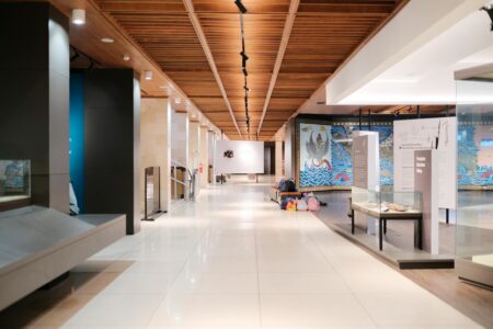 Spacious art museum gallery with paintings on white walls and polished floors