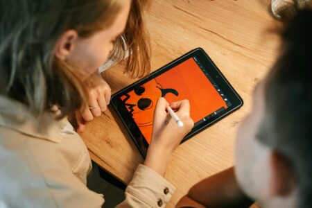 Person using stylus on digital tablet for drawing and creative work