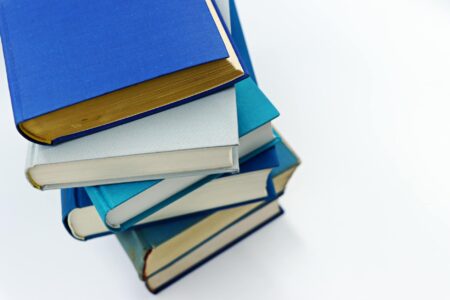 Stack of classic literature books on a wooden surface