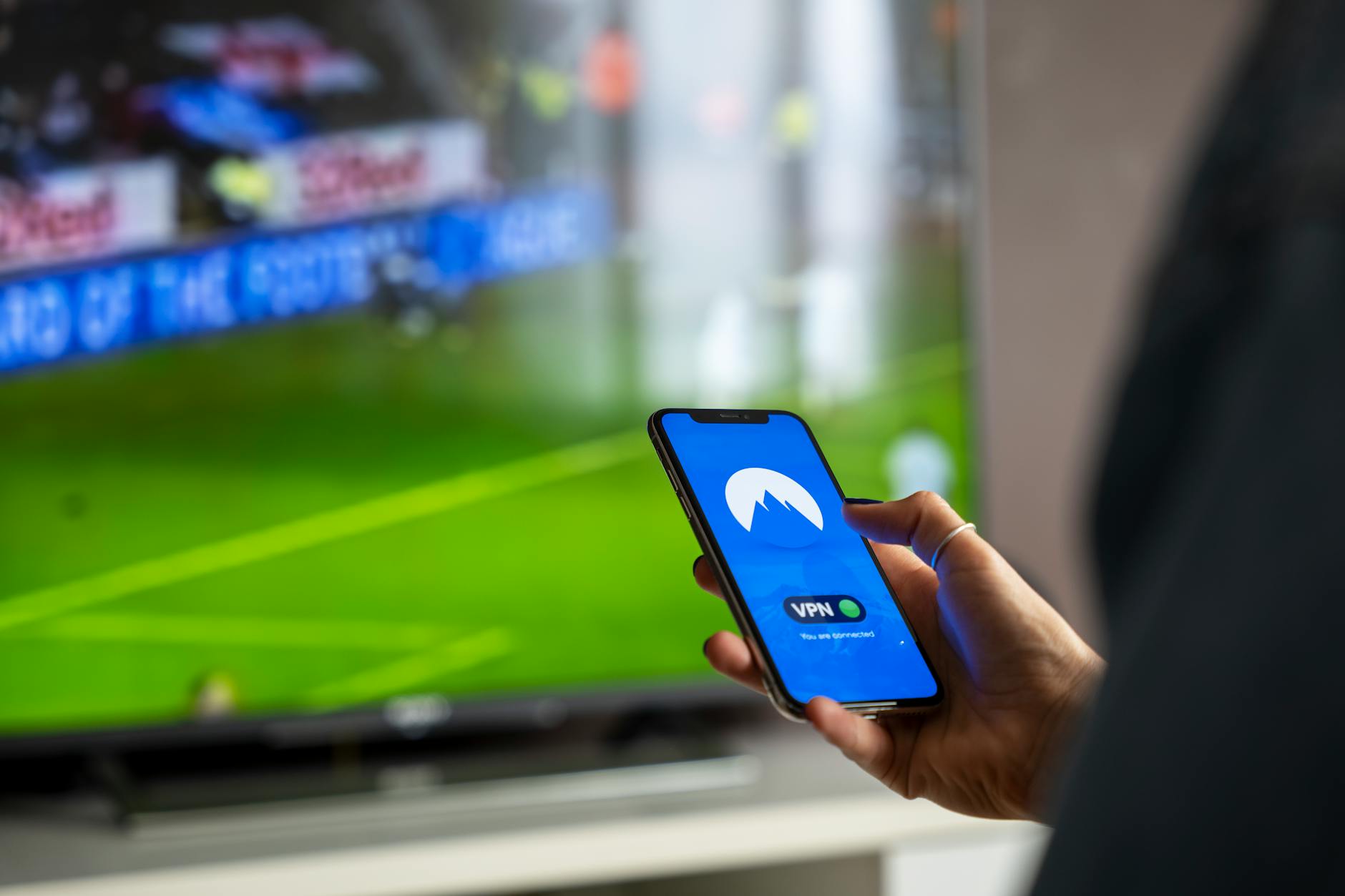 Person holding TV remote with streaming service on screen