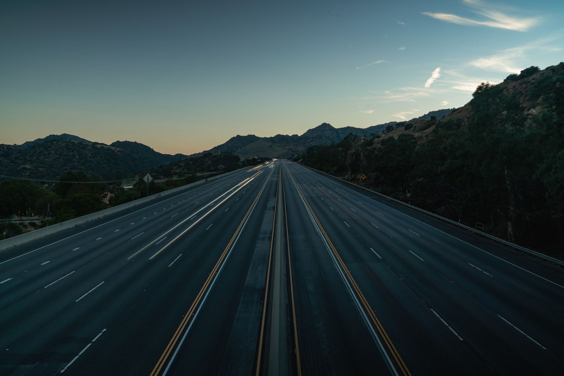 A lone traveler walking along a rural road at dawn, evoking themes of pilgrimage and journey