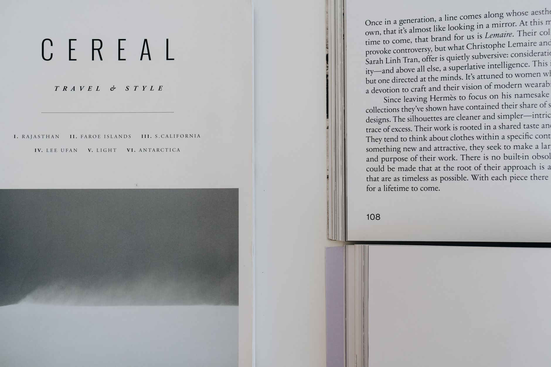 An open literary magazine resting on a wooden surface beside a cup of coffee