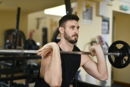 Grip Strength Is the Fitness Metric Man gripping a pull-up bar at the gym with focused expression