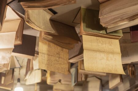 Stack of open books on a library table with soft natural light