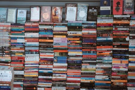 Stack of science fiction paperbacks on a wooden surface with dramatic lighting
