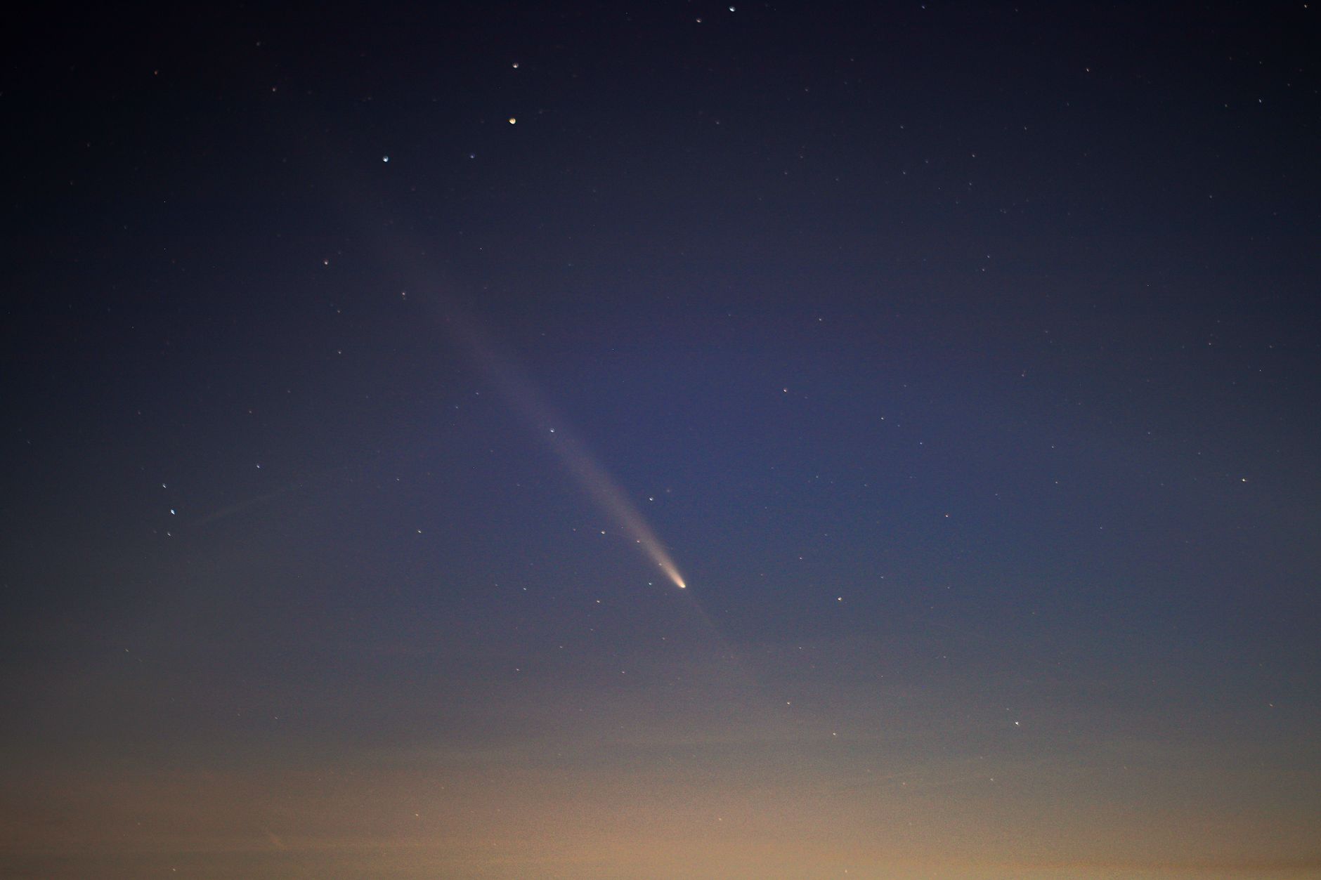Bright comet streaking across a dark night sky