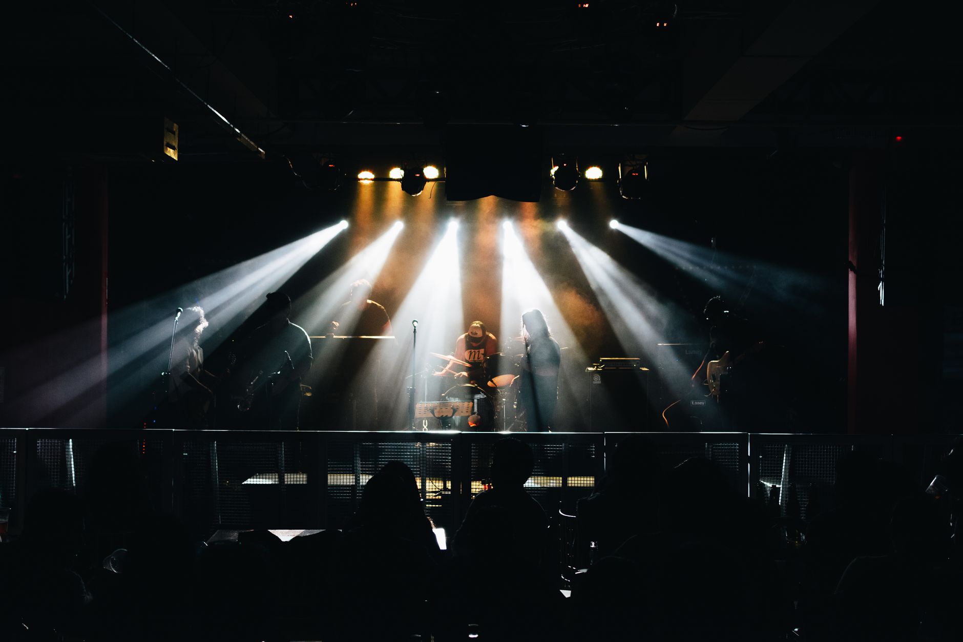 Performer under a spotlight on a darkened musical theater stage