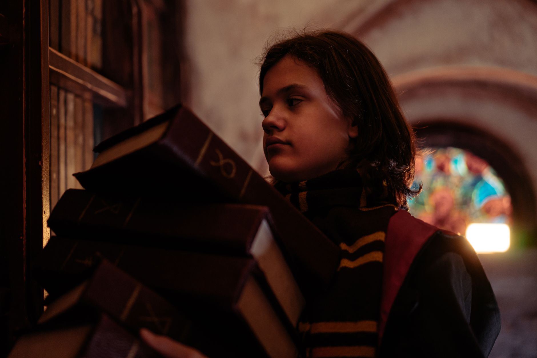 Dimly lit library shelves with shadowy gothic atmosphere