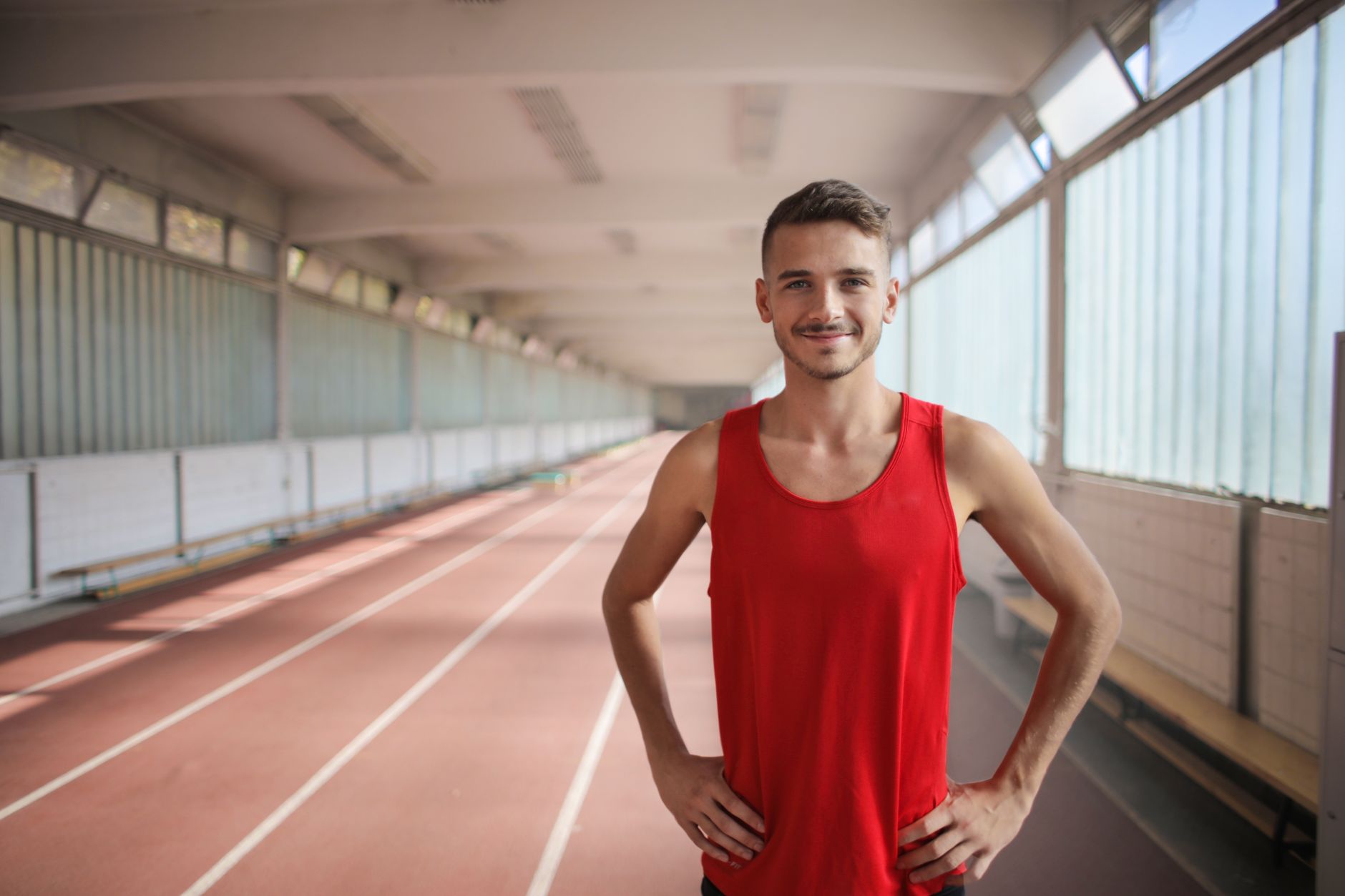 Young male athlete standing calmly in a sports environment, composed expression