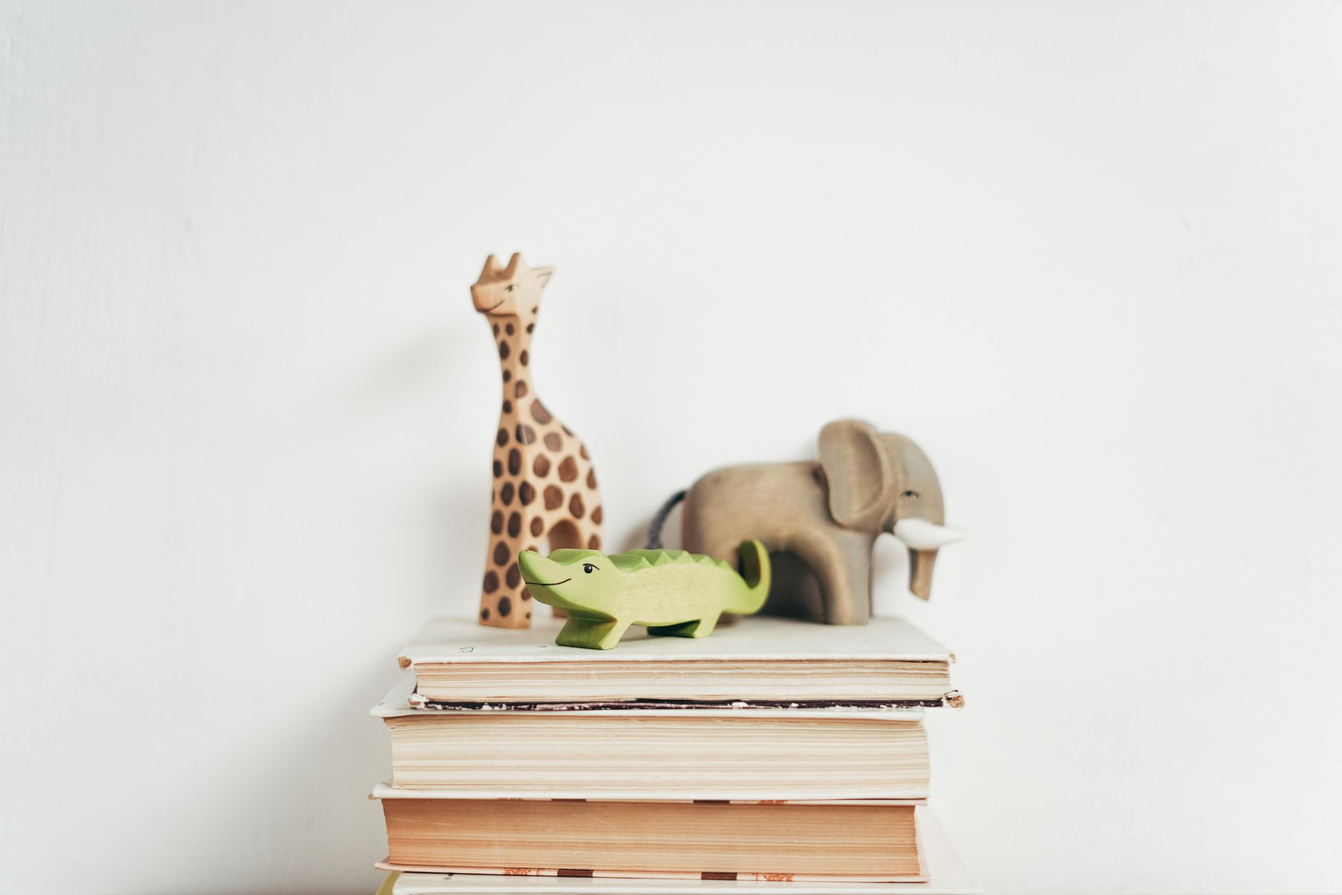 A colorful stack of children's books piled on a wooden table