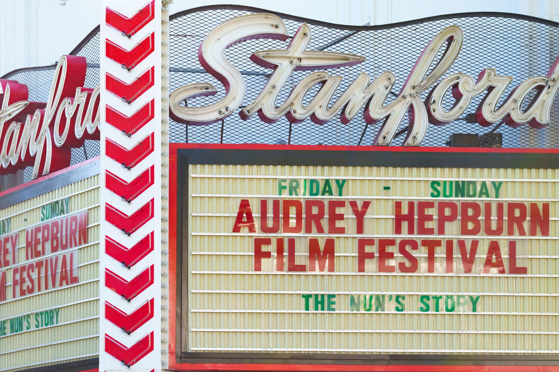 Retro cinema marquee sign lit up at night on a city street