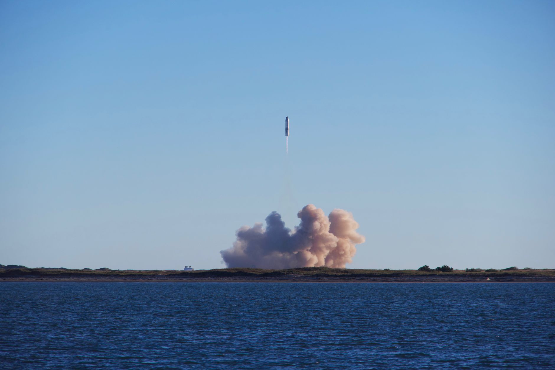 A rocket on a launch pad at dusk preparing for liftoff