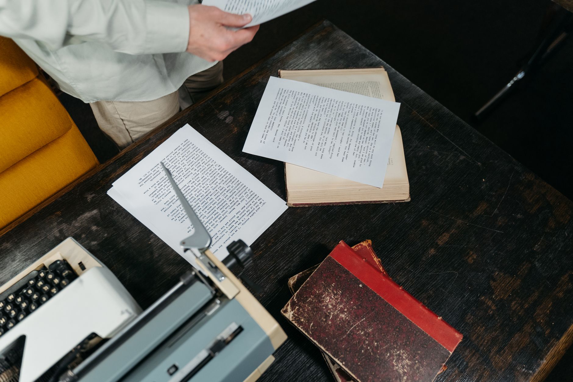 A writer's desk with a typewriter and scattered papers, suggesting the solitary process of long-form fiction writing