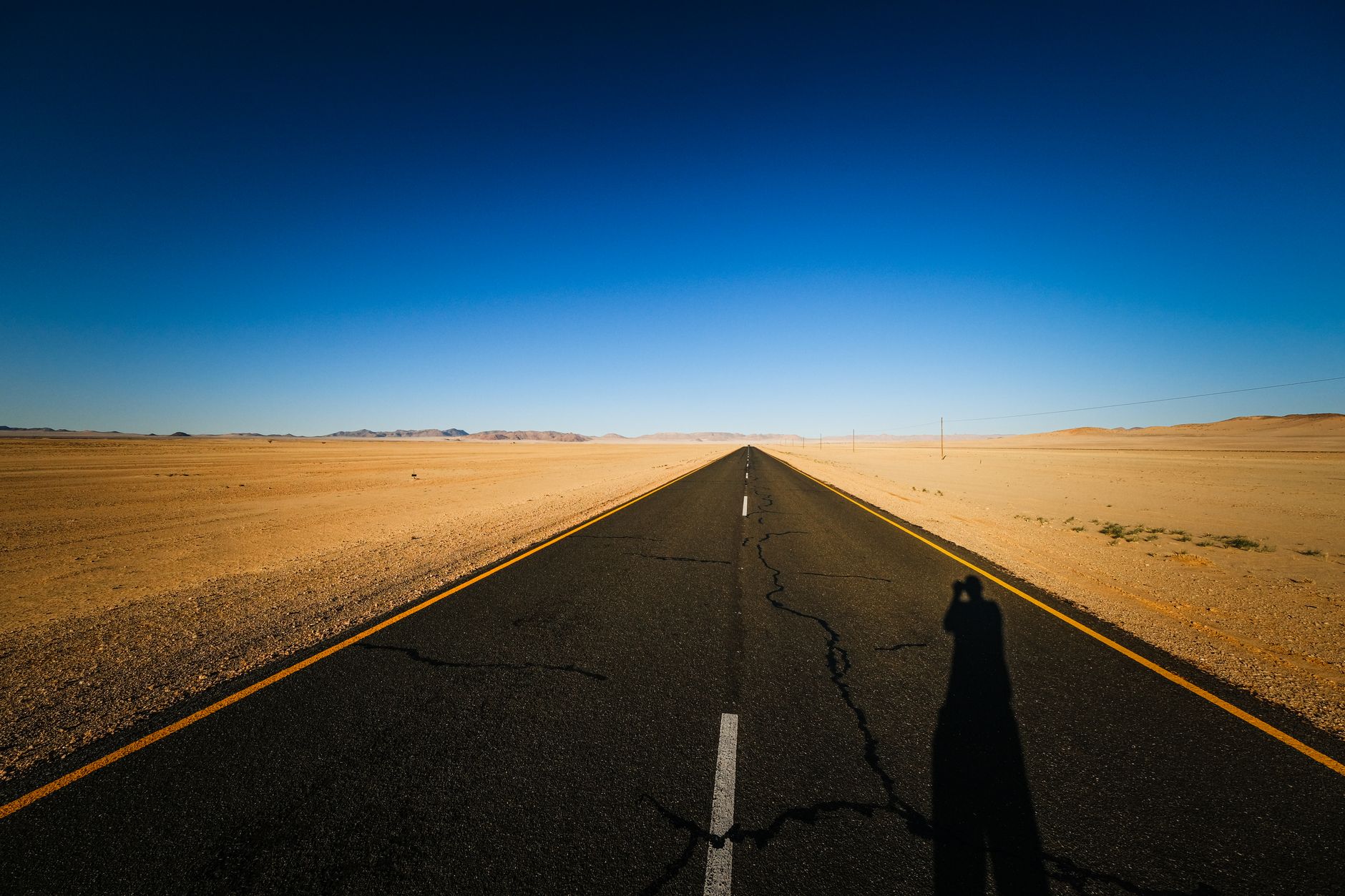 Empty desert highway stretching toward the horizon under a wide open sky