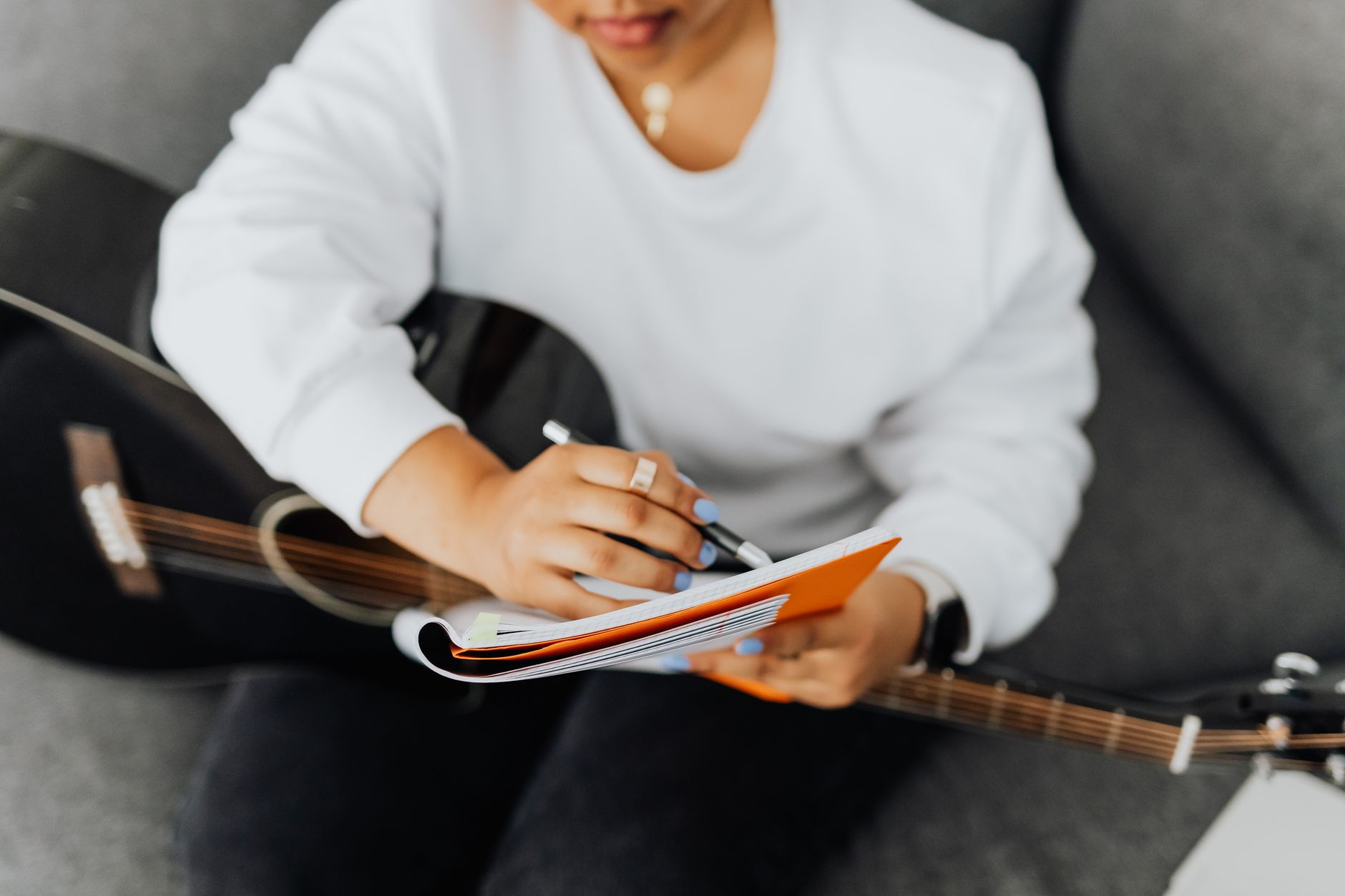 Open notebook beside a recording studio window suggesting songwriting process
