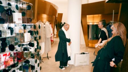 Interior of a high-end fashion boutique with minimalist displays and dark clothing racks