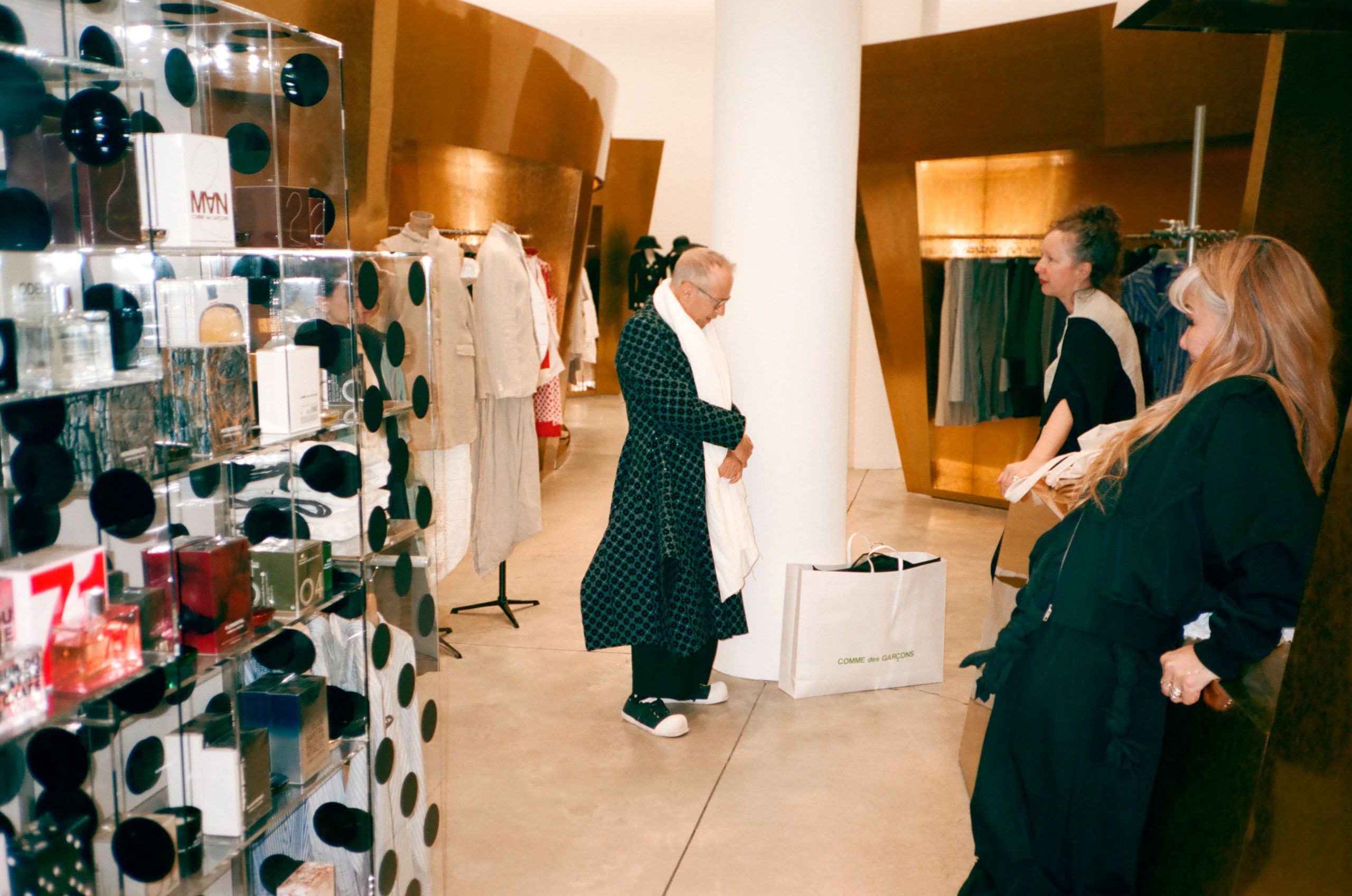 A man wearing structured, unconventional dark clothing in an urban setting