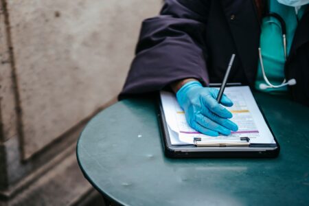 A physician reviewing paperwork at a medical office desk