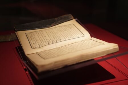 Aged parchment with handwritten text suggesting classical manuscript or ancient literary document