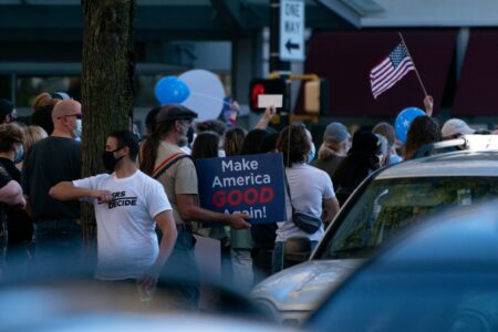 Scientists, Pop Stars, and One Cartoon: Who Americans Actually Admire People gathered beneath an American flag at a public event