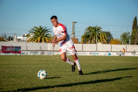 Soccer player performing a dribbling maneuver on a grass field