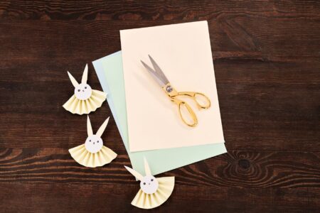 Close-up of handmade paper folded into a small animal shape on a wooden table