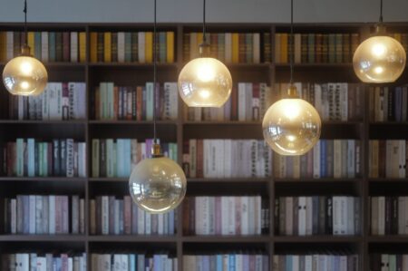 Rows of old books on wooden library shelves, evoking early twentieth century public libraries