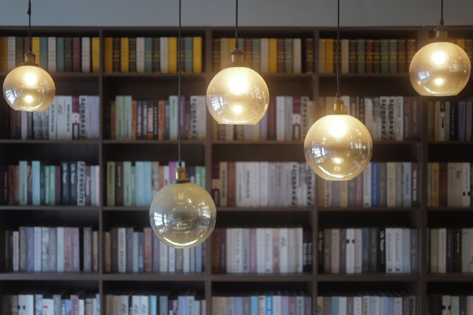 Rows of old books on wooden library shelves, evoking early twentieth century public libraries
