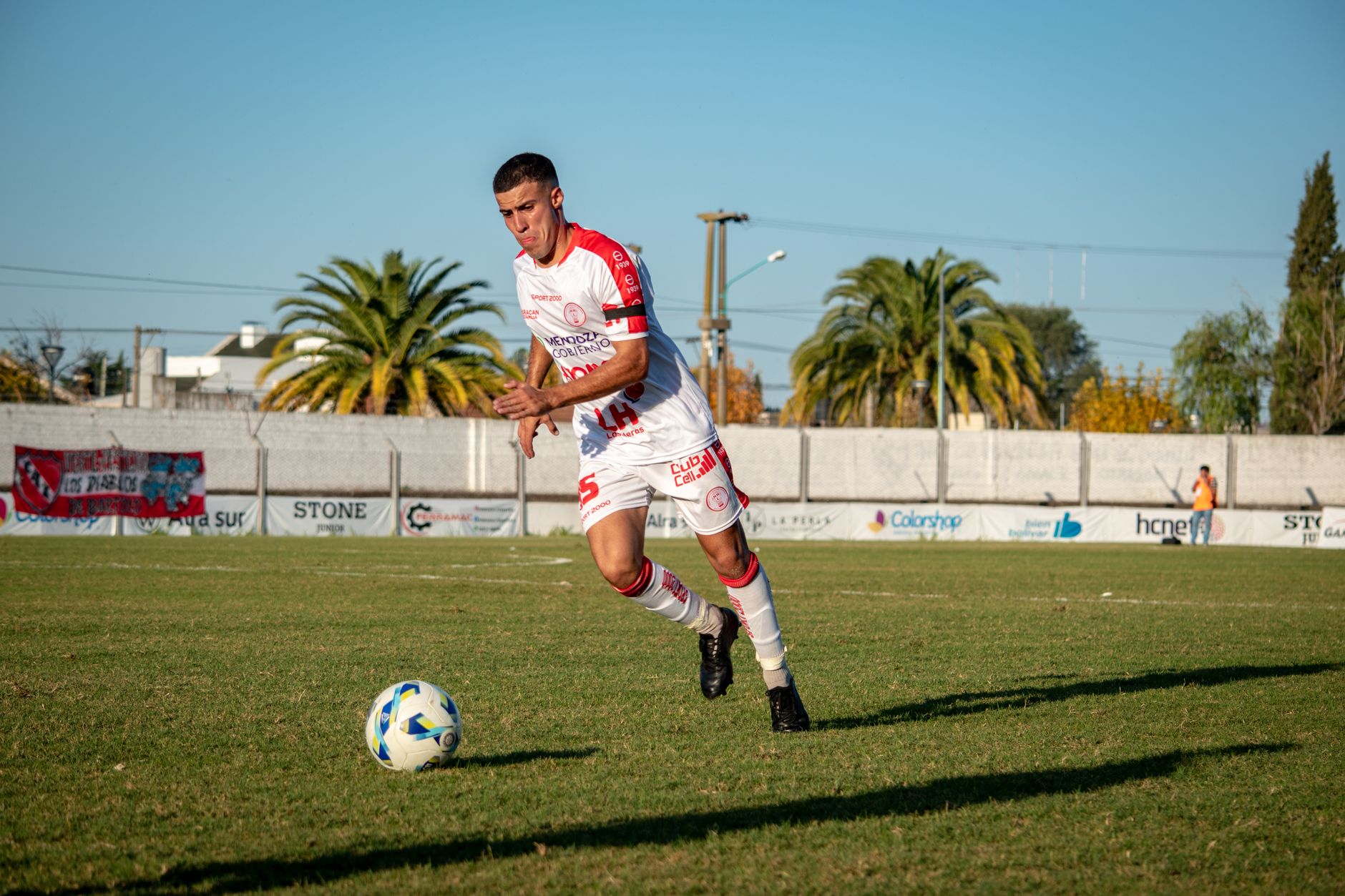 Soccer player performing a dribbling maneuver on a grass field