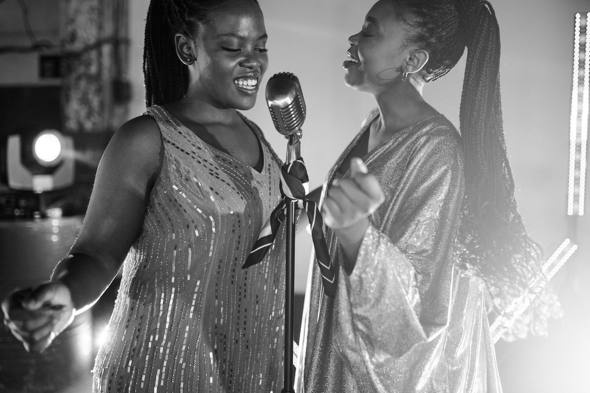 Three women singing together in close harmony, representing the vocal layering of Wilson Phillips