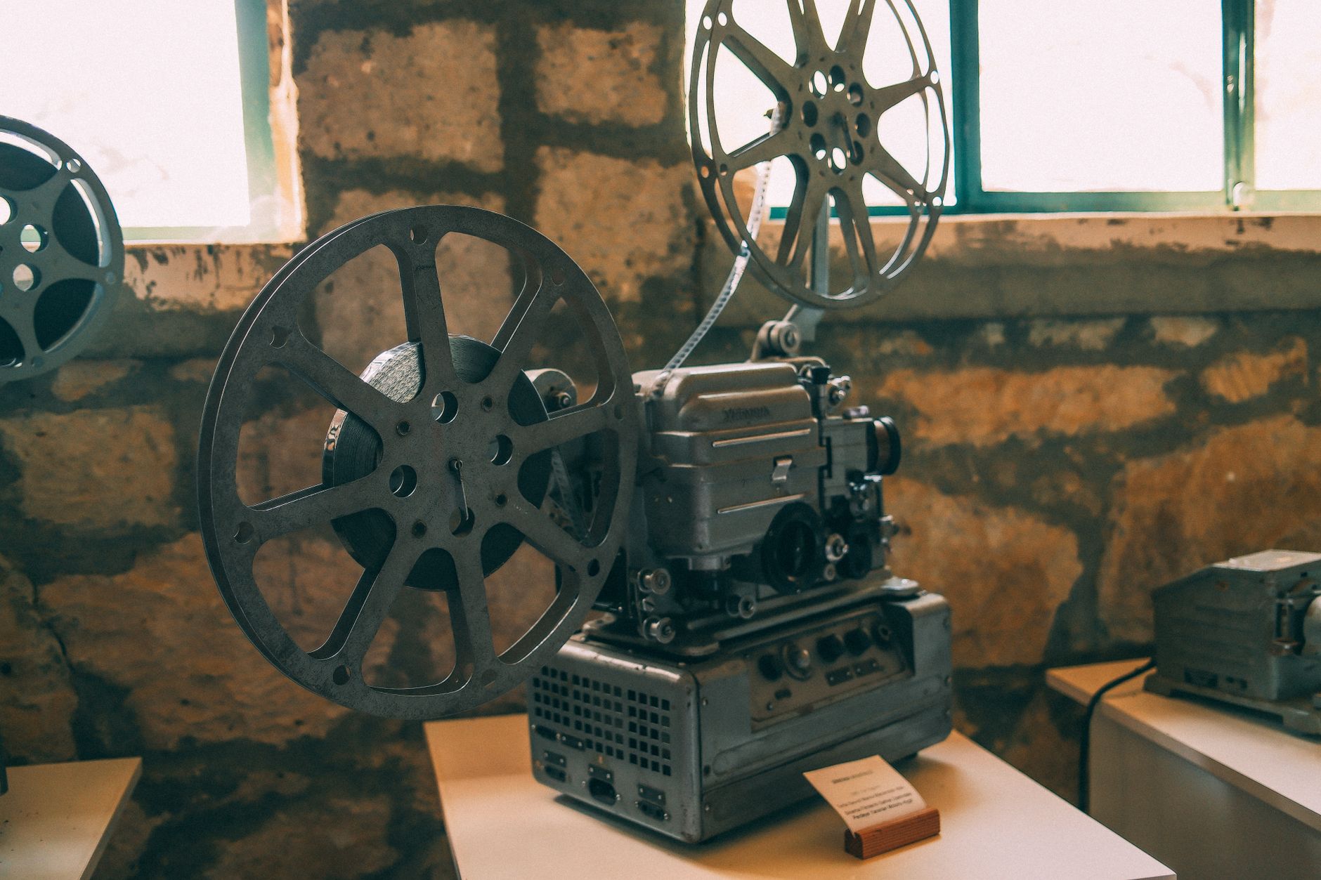 Old 35mm film reels stacked on a wooden surface in low light