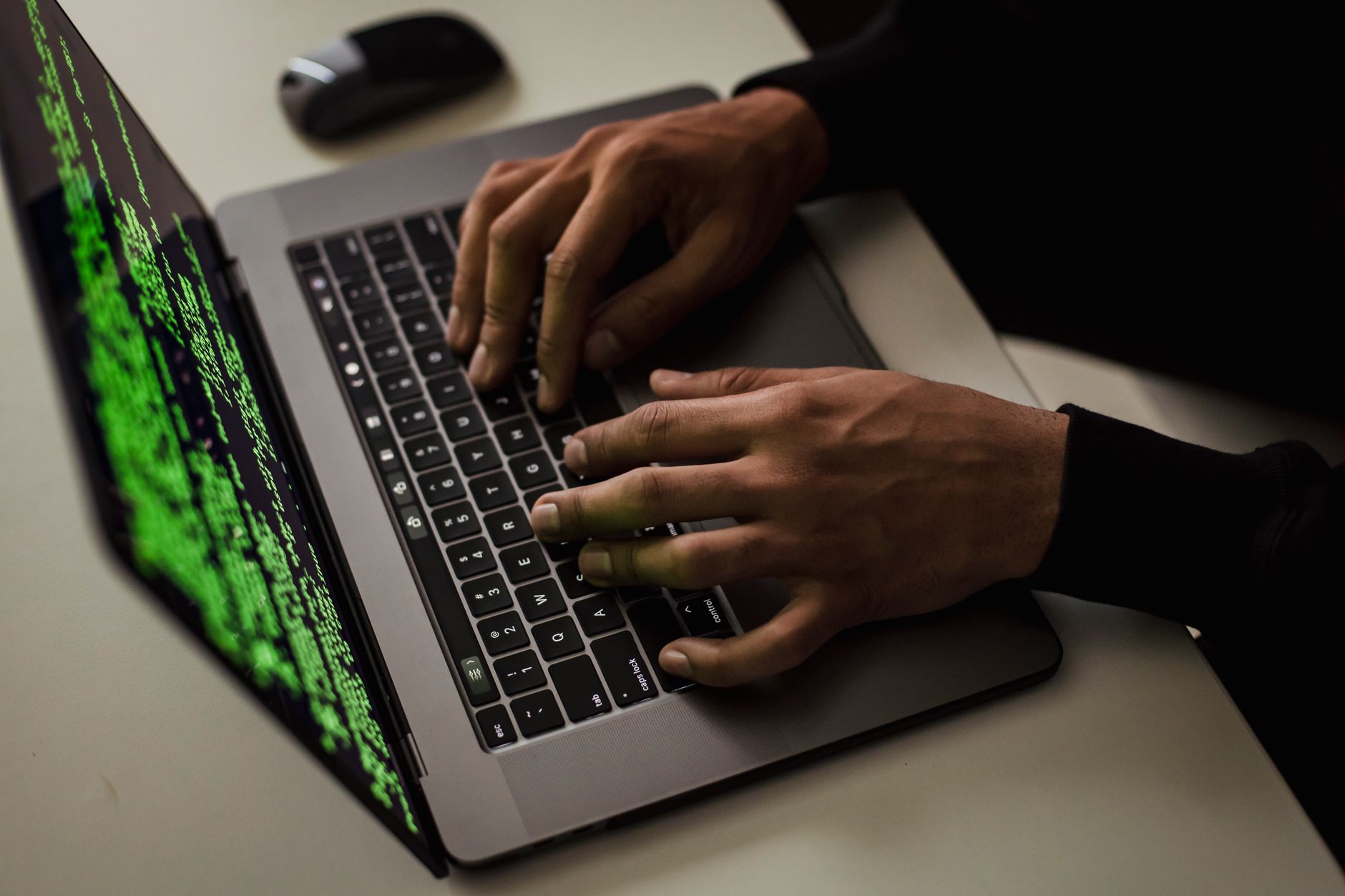 Person at a laptop in a dark room representing a low-skill cyberattack scenario