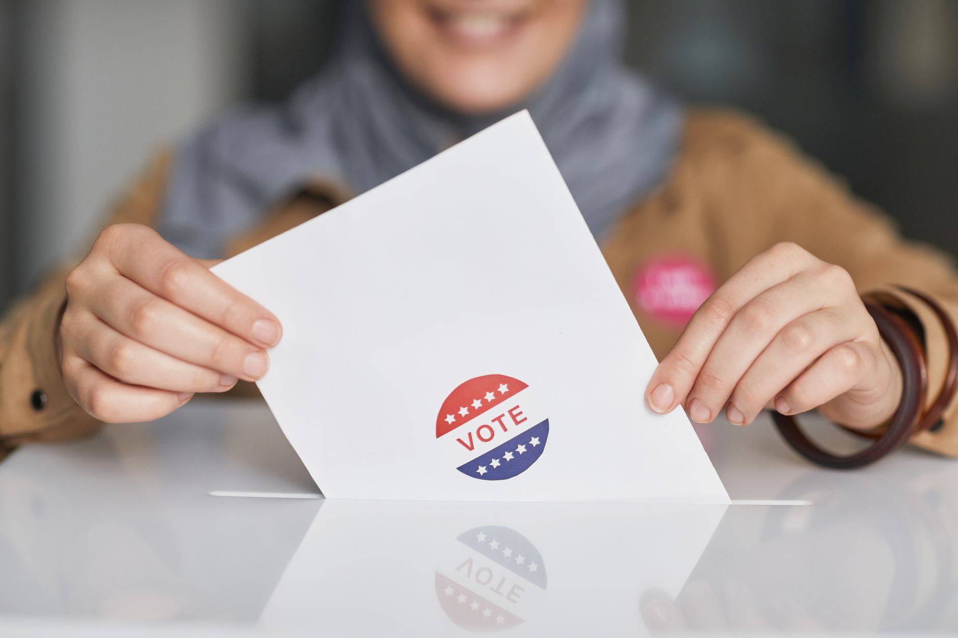 A voter placing a ballot into an official election box