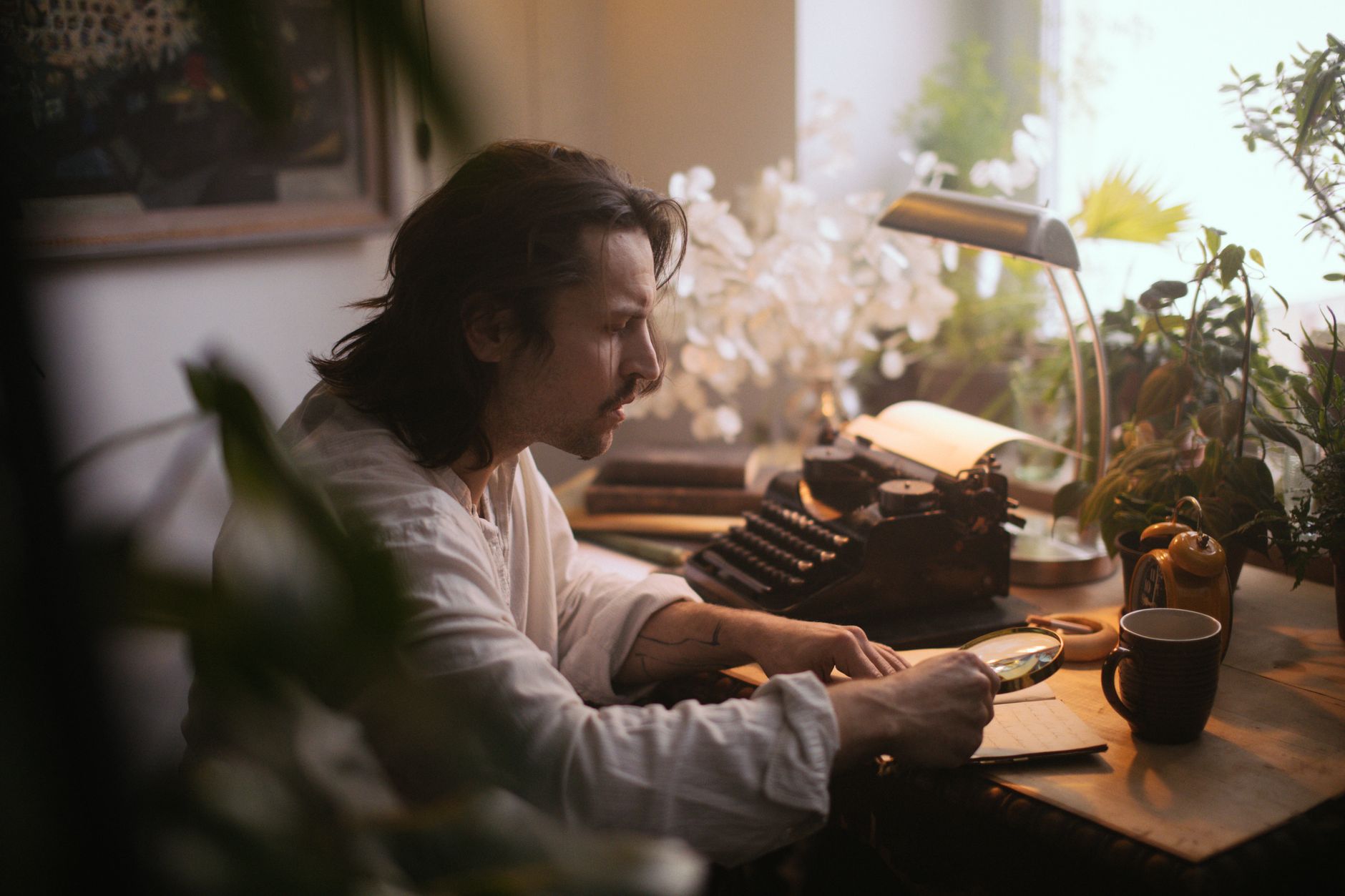 A writer's desk with open books and notes scattered across the surface