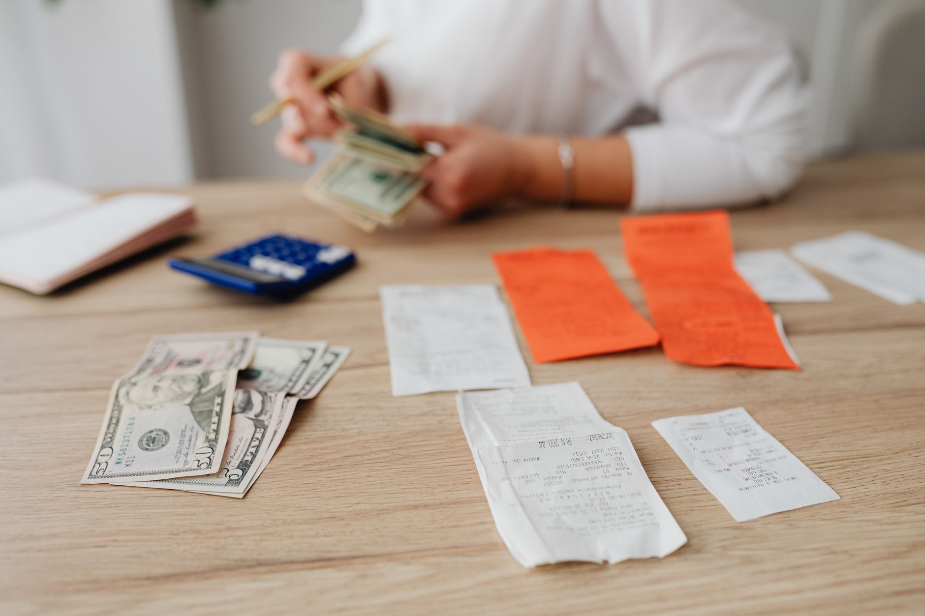 A person reviewing a paper utility bill showing itemized charges and fees