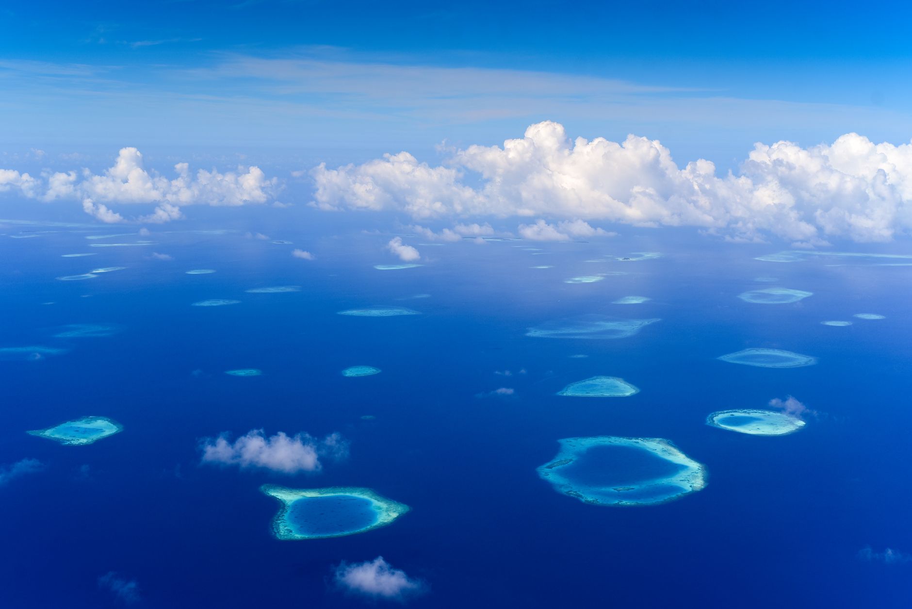 Aerial view of a remote tropical island surrounded by deep blue Pacific water