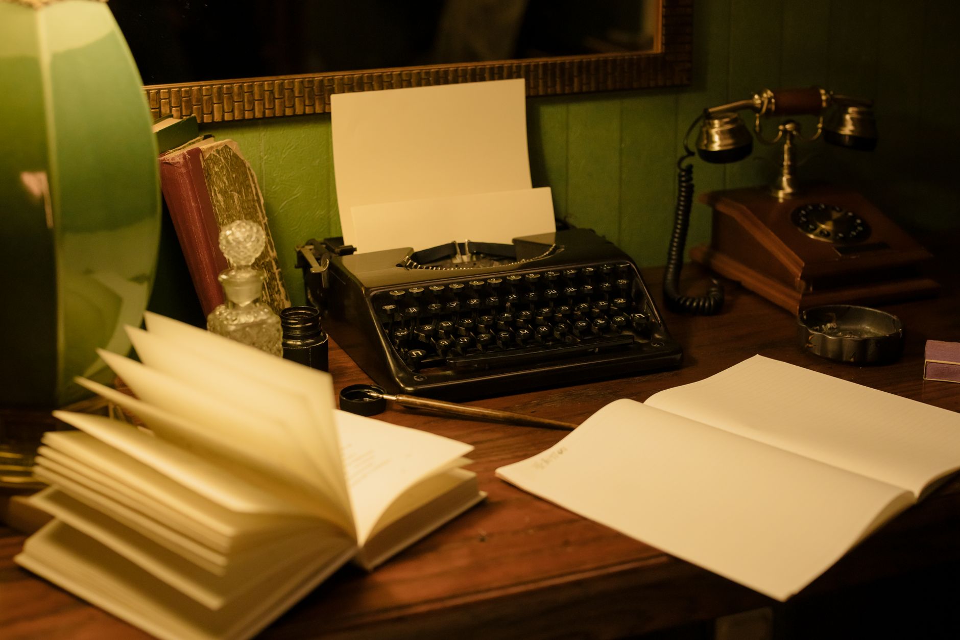 A single lamp illuminating a desk with papers and a pen