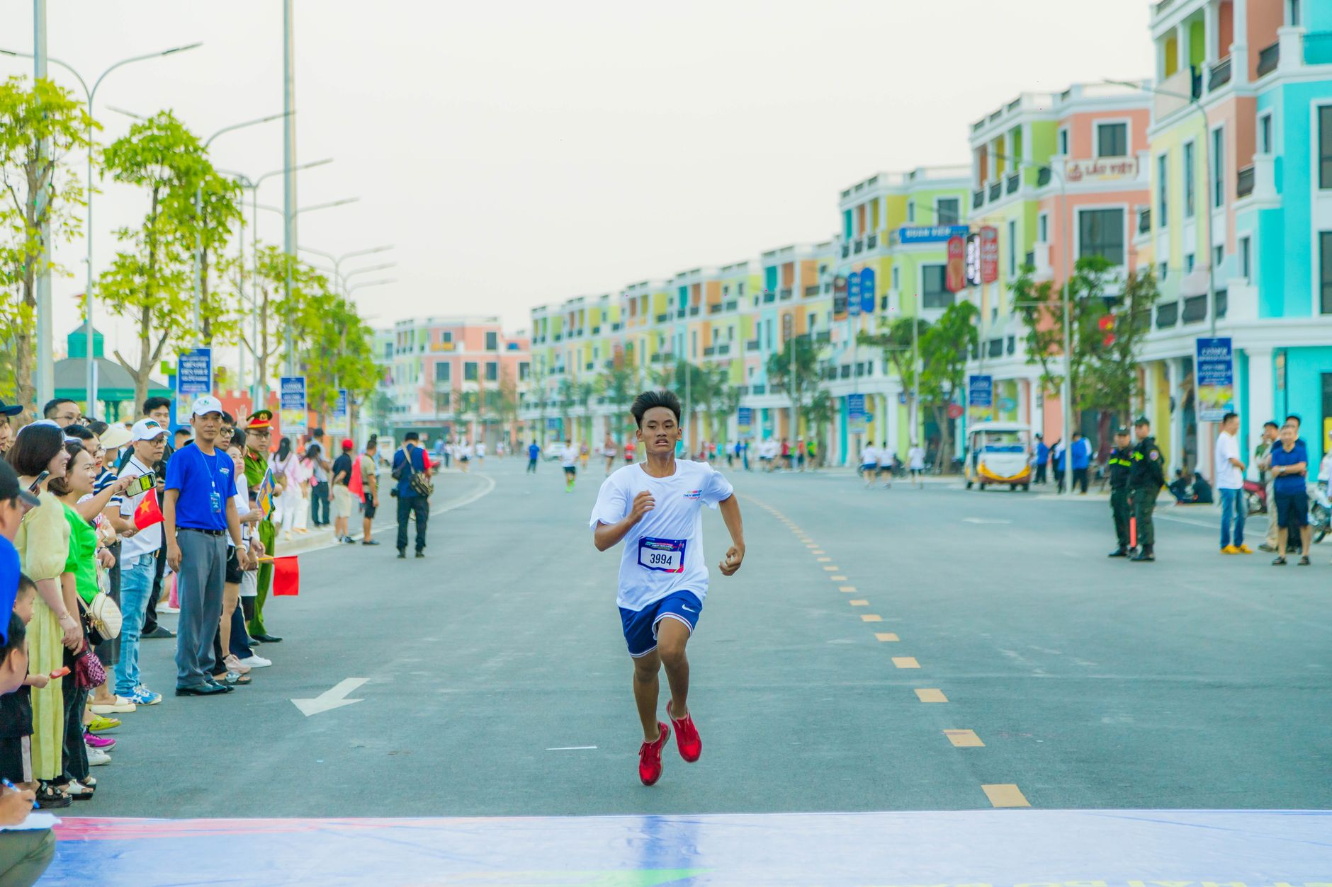 Runners crossing a marathon finish line with spectators watching