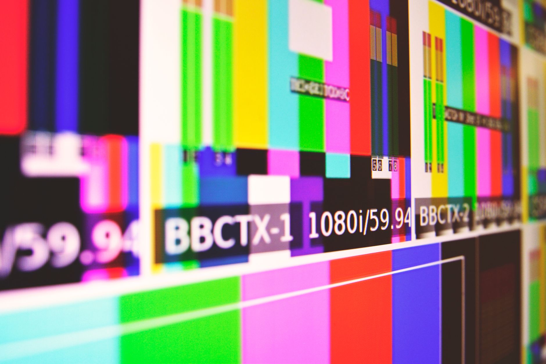 Television screen displaying a live news broadcast in a darkened room