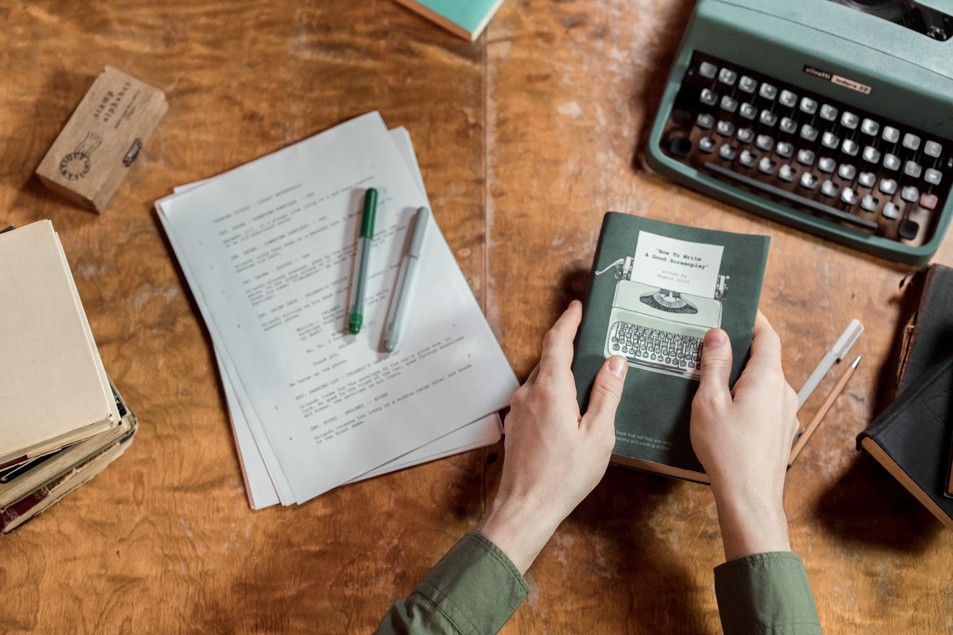 A writer's desk with an open notebook, pen, and scattered papers