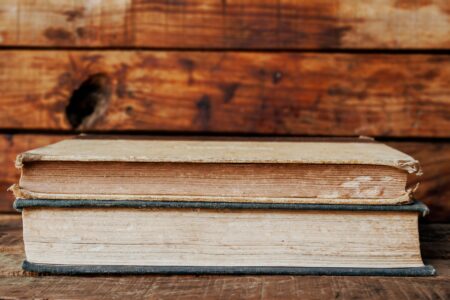 A collection of colorful vintage book covers arranged on a wooden surface