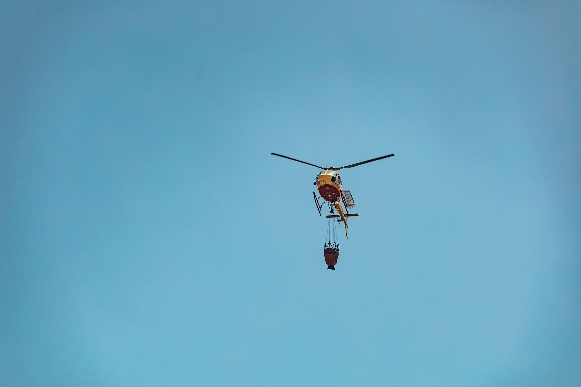 Aerial view of firefighting aircraft over burning forest terrain