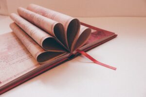 An open book of poetry resting on a wooden table, pages slightly worn