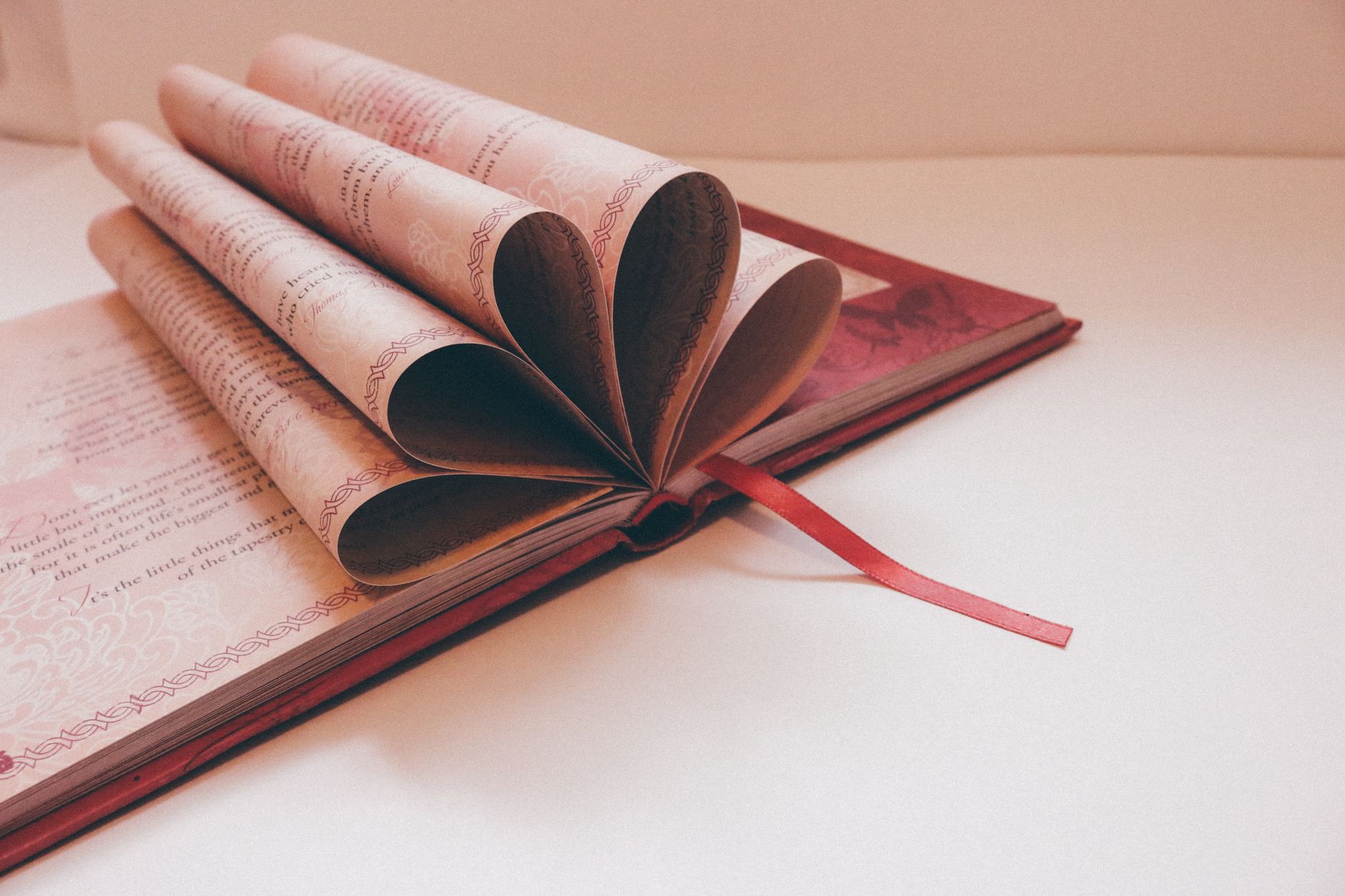 An open book of poetry resting on a wooden table, pages slightly worn
